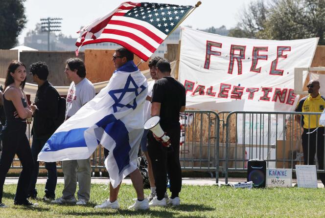 A counter-protester carries an Israeli flag and an American flag near a pro-Palestinian encampment on the campus of the University of California, Los Angeles (UCLA), April 30, 2024.