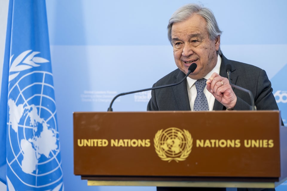 Antonio Guterres, grey hair, at the microphone of a lectern, labeled “United Nations”.